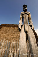 Imágenes de madera llamadas Ki’i hacen guardia sobre una reconstrucción de un templo y mausoleo que contenía los huesos de 23 ali’i. Pu’uhonua o Honaunau Nacional Historic Park. Big Island.